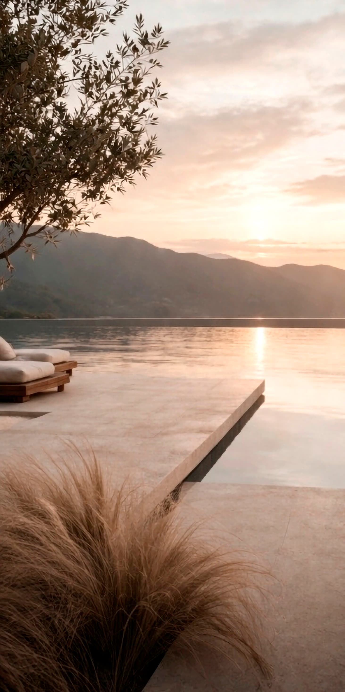 Lakeside terrace at sunrise with stone platform, quiet water, and mountain horizon