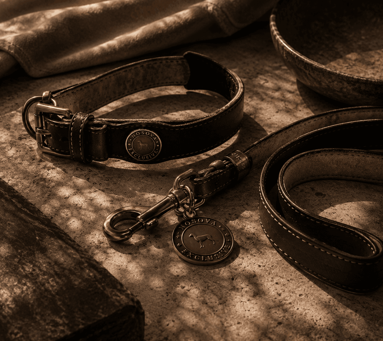 Leather collar and leash set arranged on warm stone at Sighthound Sanctuary.